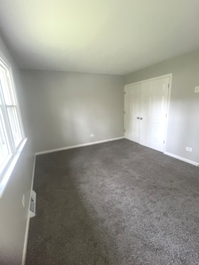 unfurnished bedroom with dark colored carpet