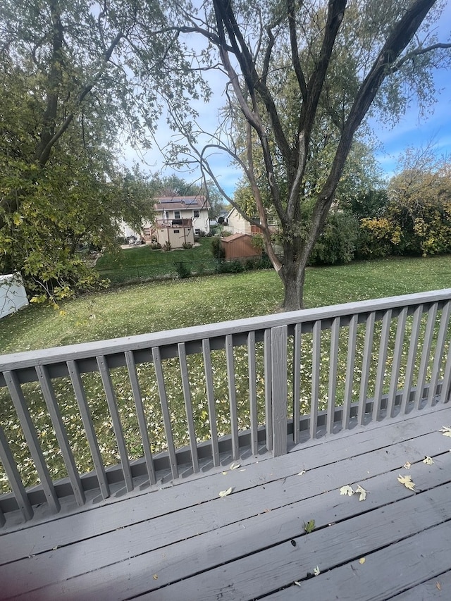 wooden deck featuring a lawn