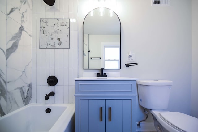 full bathroom featuring tiled shower / bath, vanity, and toilet