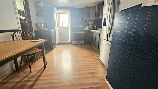 kitchen with washer / clothes dryer, light hardwood / wood-style flooring, and tile walls