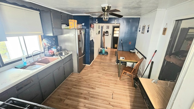 kitchen featuring stainless steel fridge, a textured ceiling, ceiling fan, sink, and hardwood / wood-style floors