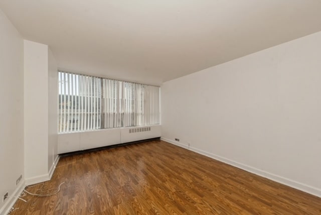 unfurnished room with dark wood-type flooring