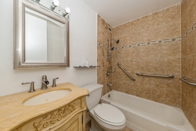 full bathroom featuring vanity, toilet, and tiled shower / bath combo