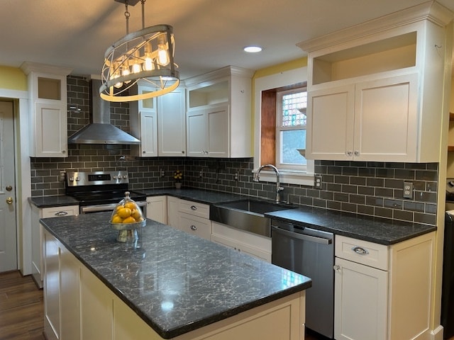 kitchen with backsplash, white cabinetry, stainless steel appliances, wall chimney exhaust hood, and pendant lighting