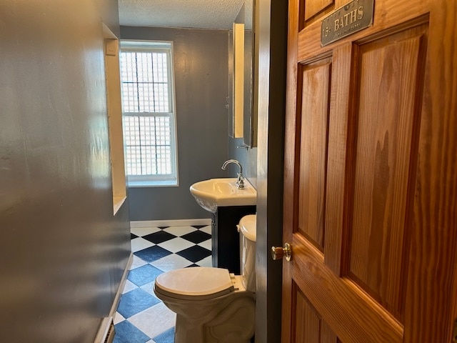 bathroom with toilet, a textured ceiling, and vanity