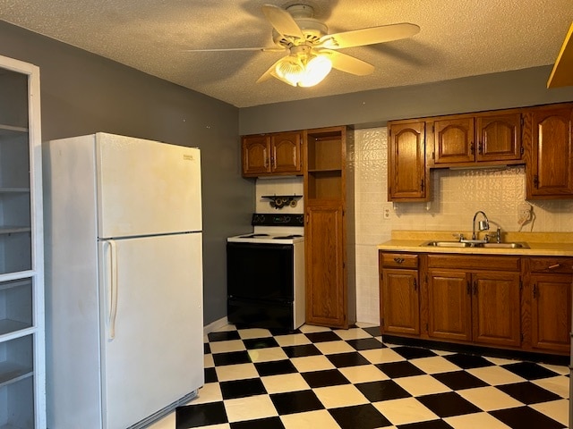 kitchen featuring sink, a textured ceiling, white appliances, and ceiling fan