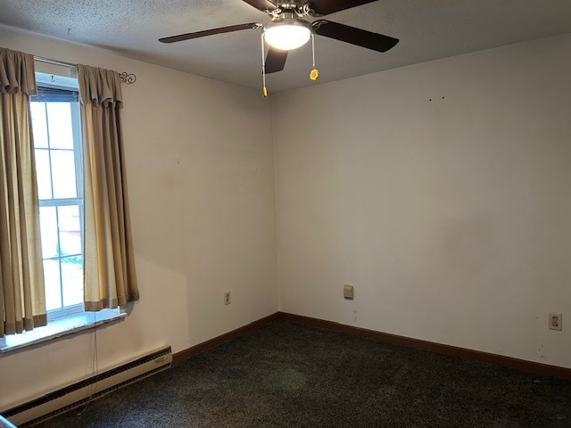 empty room with ceiling fan, a textured ceiling, a baseboard heating unit, and dark carpet