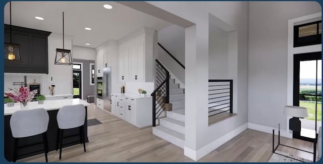 kitchen with white cabinets, light hardwood / wood-style flooring, and backsplash