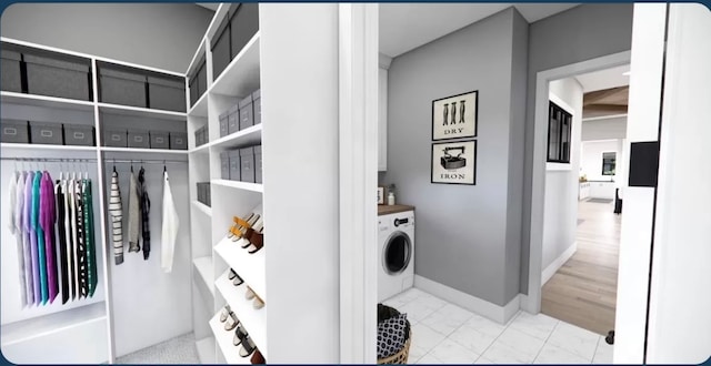 clothes washing area with light hardwood / wood-style floors and washer / clothes dryer