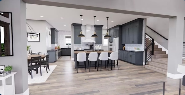 kitchen featuring a kitchen island, light hardwood / wood-style flooring, a breakfast bar, decorative light fixtures, and tasteful backsplash