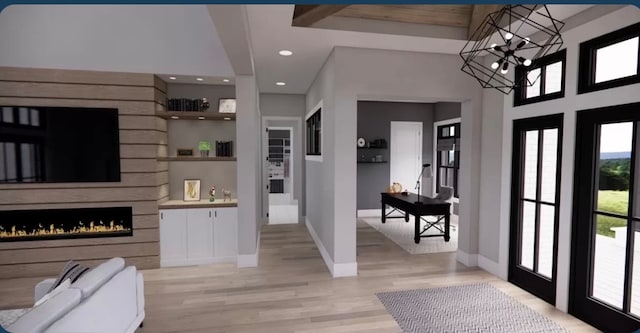 foyer featuring a towering ceiling, an inviting chandelier, and light wood-type flooring