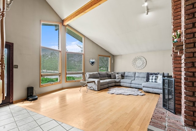 living room with lofted ceiling with beams and light hardwood / wood-style flooring