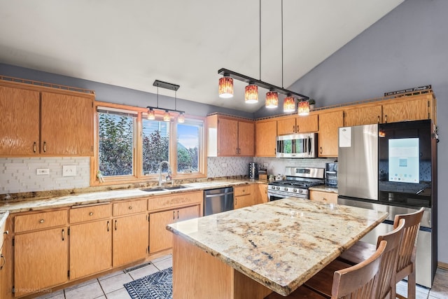 kitchen featuring vaulted ceiling, stainless steel appliances, sink, pendant lighting, and a center island