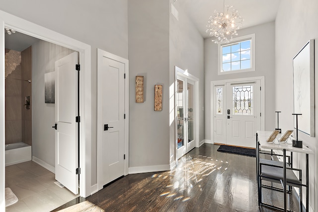 foyer featuring dark wood-type flooring, a high ceiling, and a notable chandelier