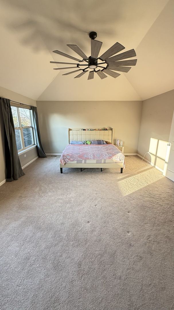 unfurnished bedroom with carpet, vaulted ceiling, and ceiling fan