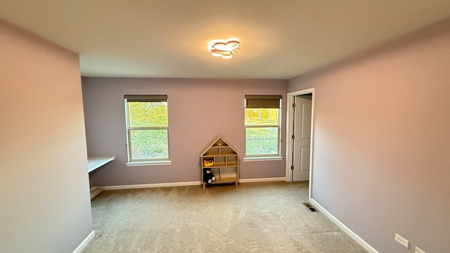 carpeted empty room featuring plenty of natural light