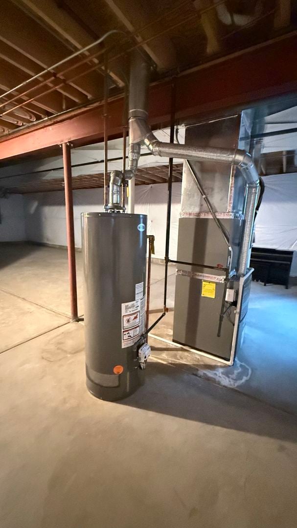 utility room with heating unit and water heater