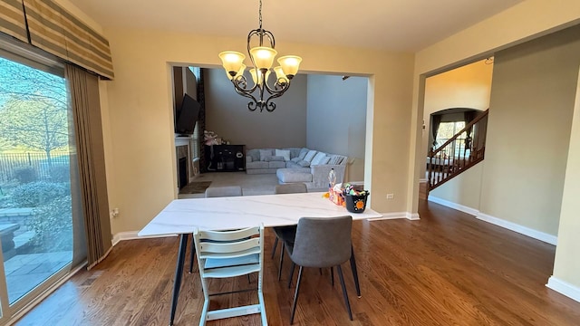 dining area featuring dark wood-type flooring, a chandelier, and plenty of natural light