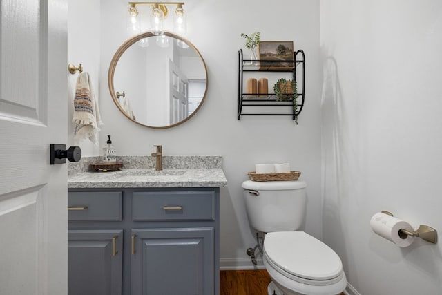 bathroom featuring wood-type flooring, vanity, and toilet