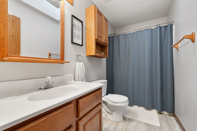 bathroom with a shower with curtain, vanity, hardwood / wood-style flooring, and toilet