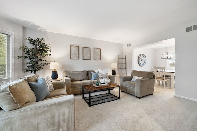 living room with a chandelier and light colored carpet