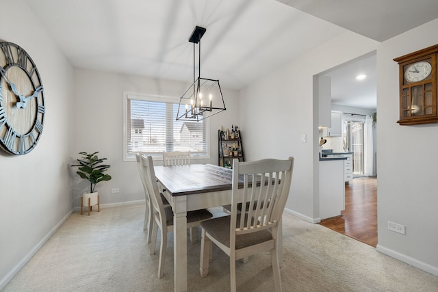 carpeted dining space featuring an inviting chandelier