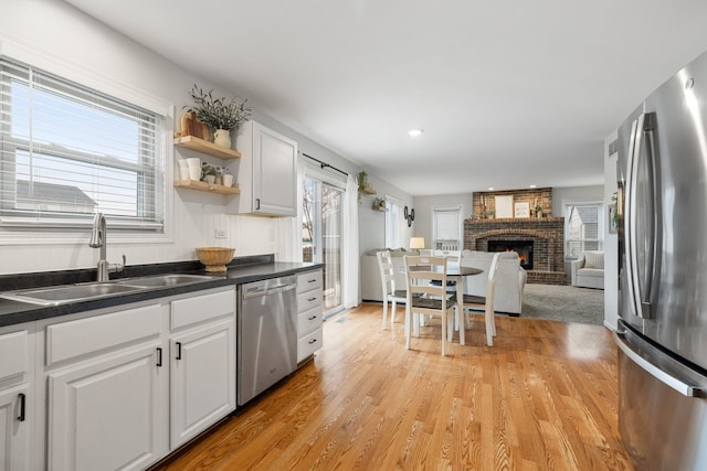 kitchen with appliances with stainless steel finishes, white cabinetry, plenty of natural light, and sink