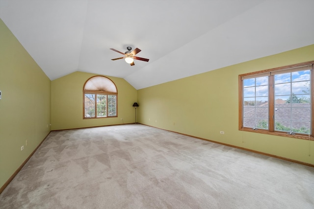 additional living space with lofted ceiling, light colored carpet, and ceiling fan