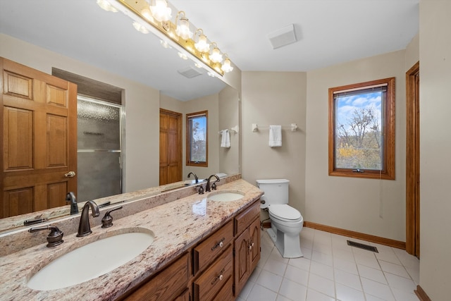 bathroom featuring toilet, vanity, tile patterned flooring, and a shower with door