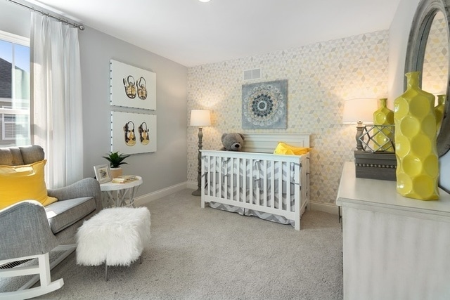 bedroom with light carpet and a nursery area