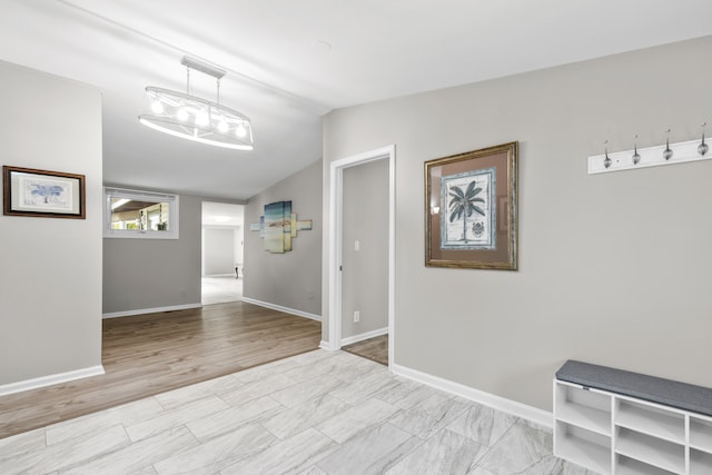 corridor featuring light hardwood / wood-style flooring and vaulted ceiling