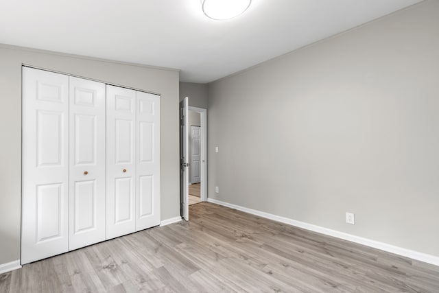 unfurnished bedroom featuring light hardwood / wood-style flooring and a closet