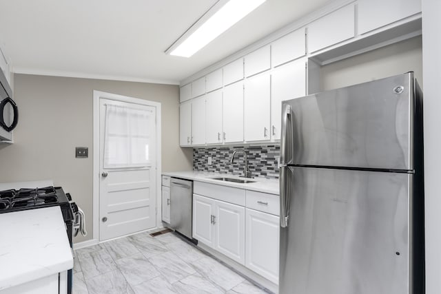 kitchen with sink, white cabinetry, stainless steel appliances, vaulted ceiling, and crown molding