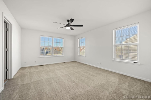 spare room featuring light colored carpet and ceiling fan