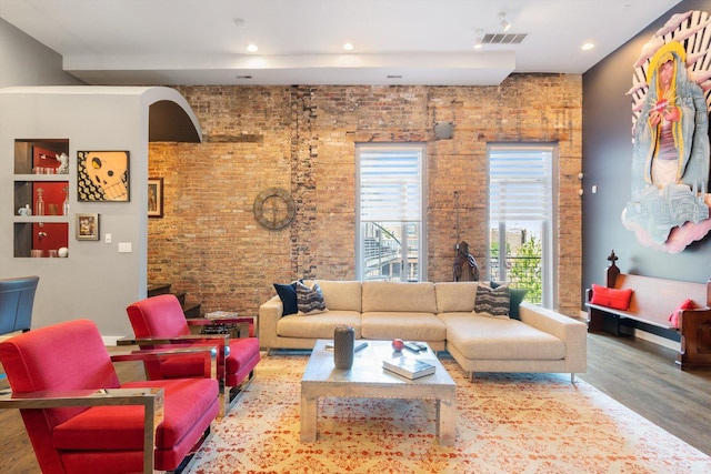 living area featuring visible vents, recessed lighting, brick wall, and wood finished floors