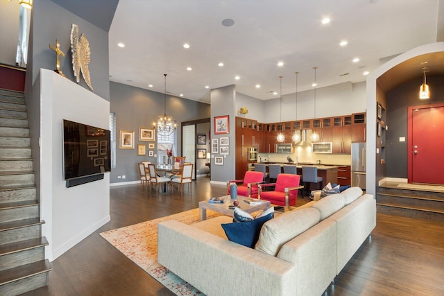 living area featuring stairway, recessed lighting, dark wood-type flooring, and a high ceiling