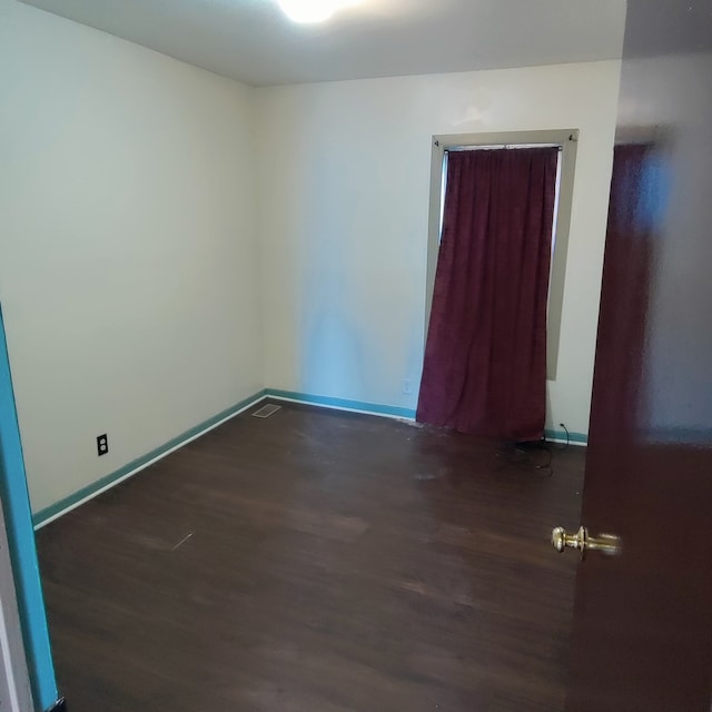 unfurnished room with dark hardwood / wood-style floors