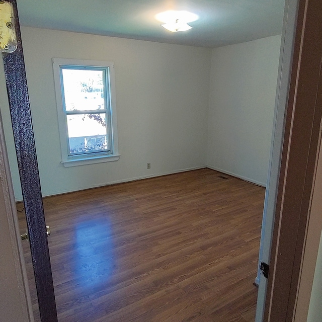 spare room featuring dark wood-type flooring