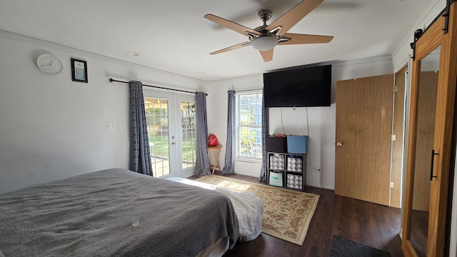 bedroom featuring ceiling fan, dark hardwood / wood-style floors, a barn door, and access to exterior