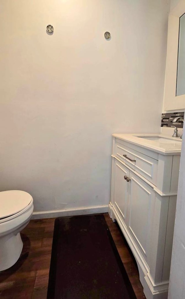 bathroom featuring vanity, toilet, and hardwood / wood-style floors