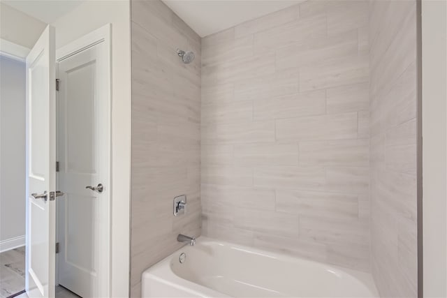 bathroom featuring wood-type flooring and tiled shower / bath