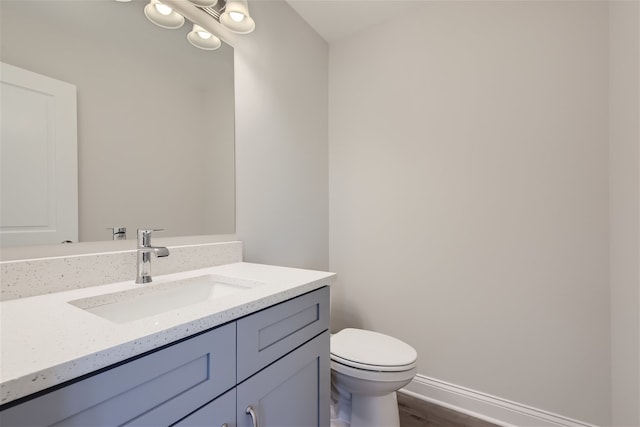 bathroom featuring vanity, toilet, and hardwood / wood-style floors