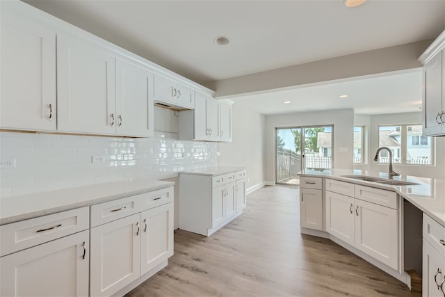 kitchen with light hardwood / wood-style flooring, white cabinetry, and sink