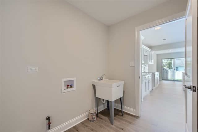 laundry room with light hardwood / wood-style floors and washer hookup