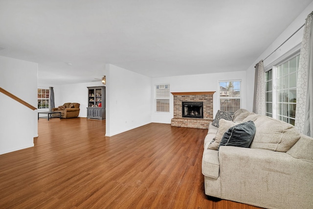 living room with a fireplace, hardwood / wood-style floors, ceiling fan, and plenty of natural light