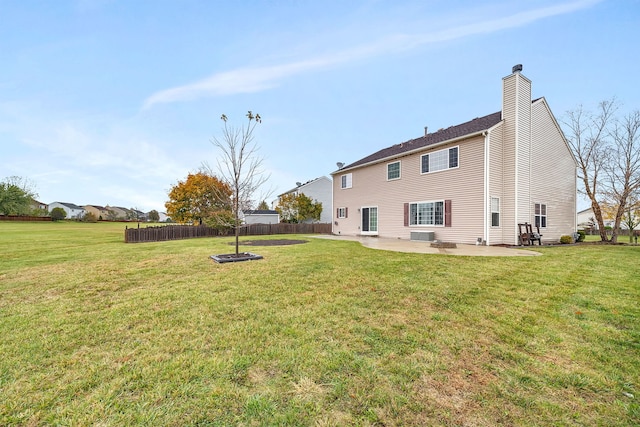 back of house with a lawn, a fire pit, and a patio area