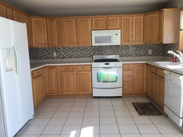 kitchen featuring decorative backsplash, white appliances, sink, and light tile patterned floors