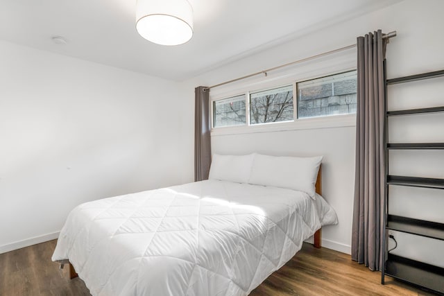 bedroom with dark hardwood / wood-style floors