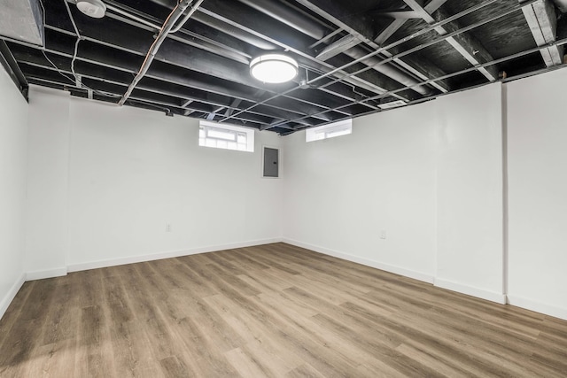 basement with electric panel and wood-type flooring