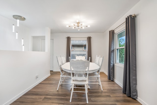 dining room with dark wood-type flooring and a notable chandelier